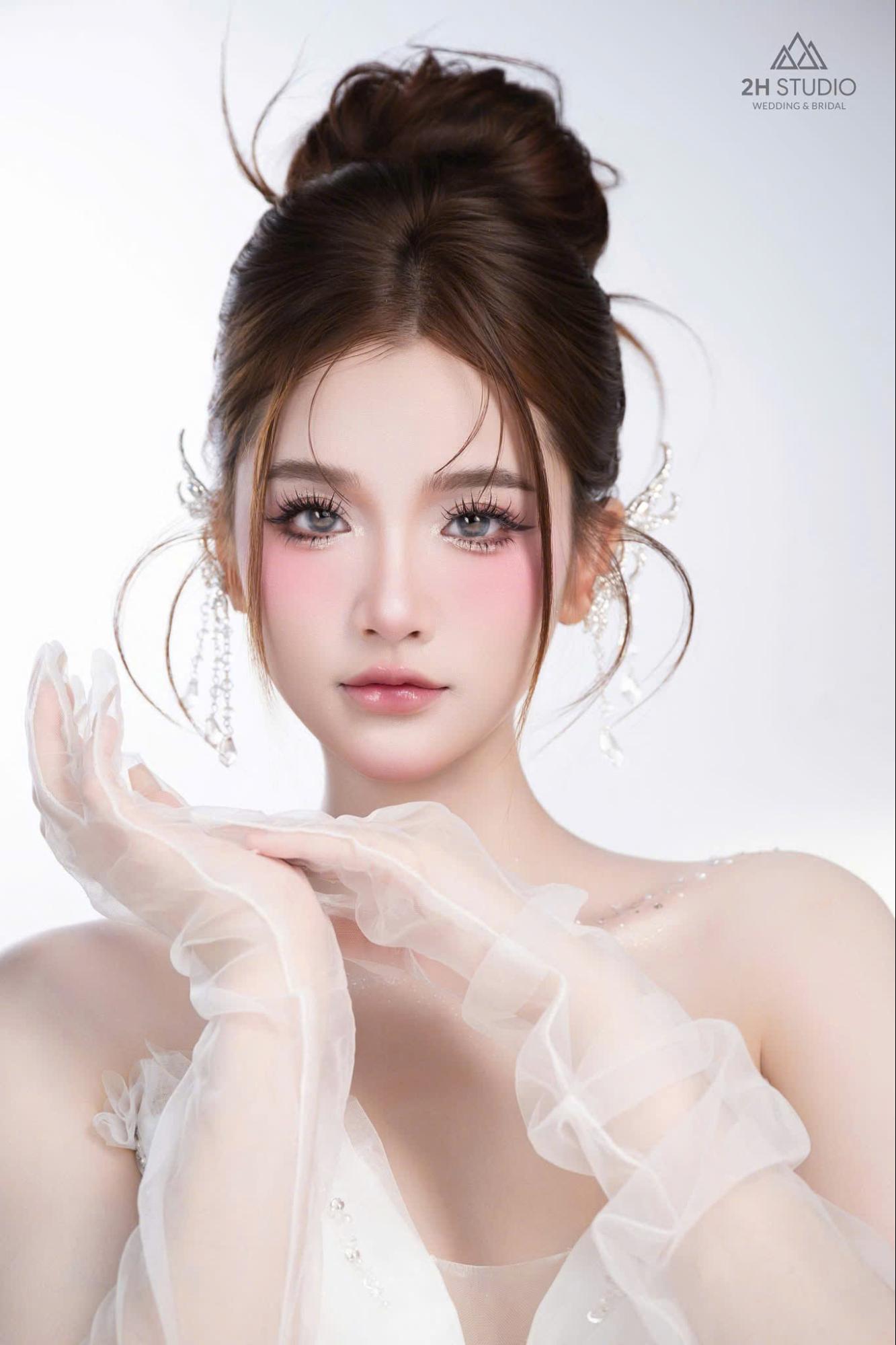 Mẫu tóc cô dâu búi cao có mái bay ấn tượng